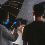 Capture of a photoshoot with people and equipment in a professional studio.