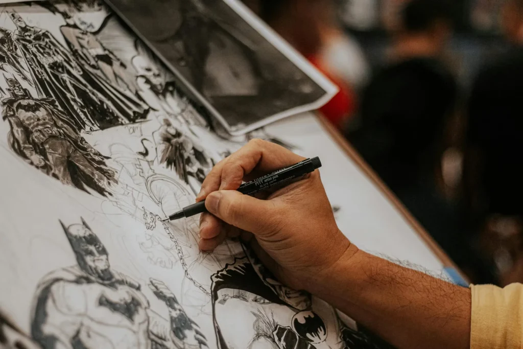 Artist drawing detailed comic book characters with a pen at a lively event.
