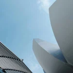 Dynamic view of sleek architectural designs reaching into a clear blue sky.