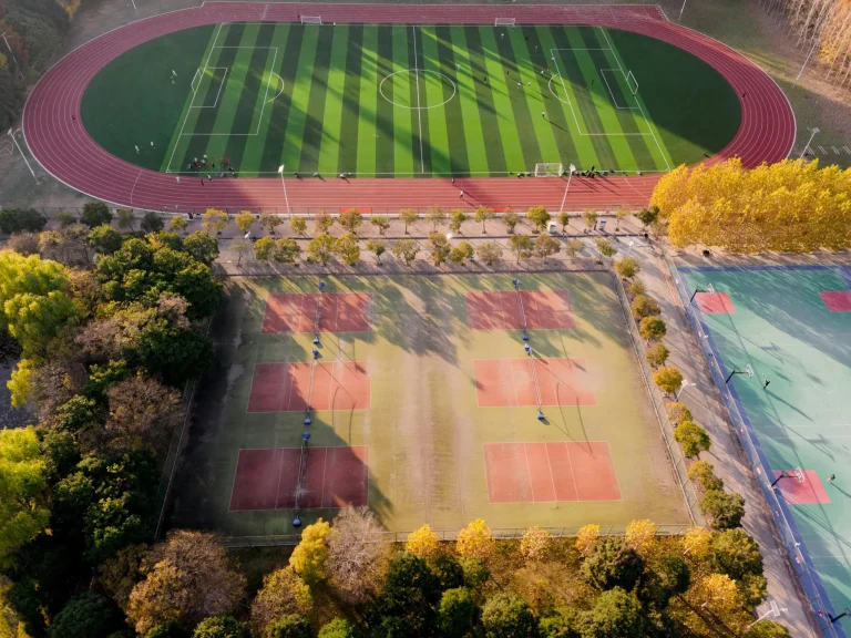 Aerial photograph of a football and tennis court in Nanjing, China during autumn.